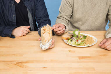 two men eating chipotle and salad