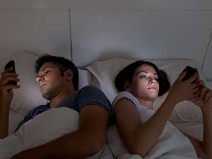 man and woman in bed on smartphones