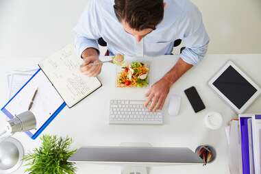 Man eating salad at work