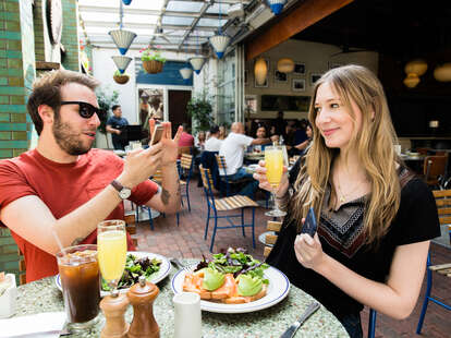 Couple taking photos of each other at brunch