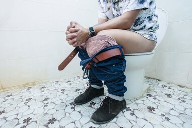 man sitting on toilet