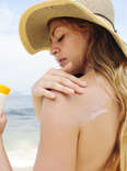 woman applying sunblock on the beach