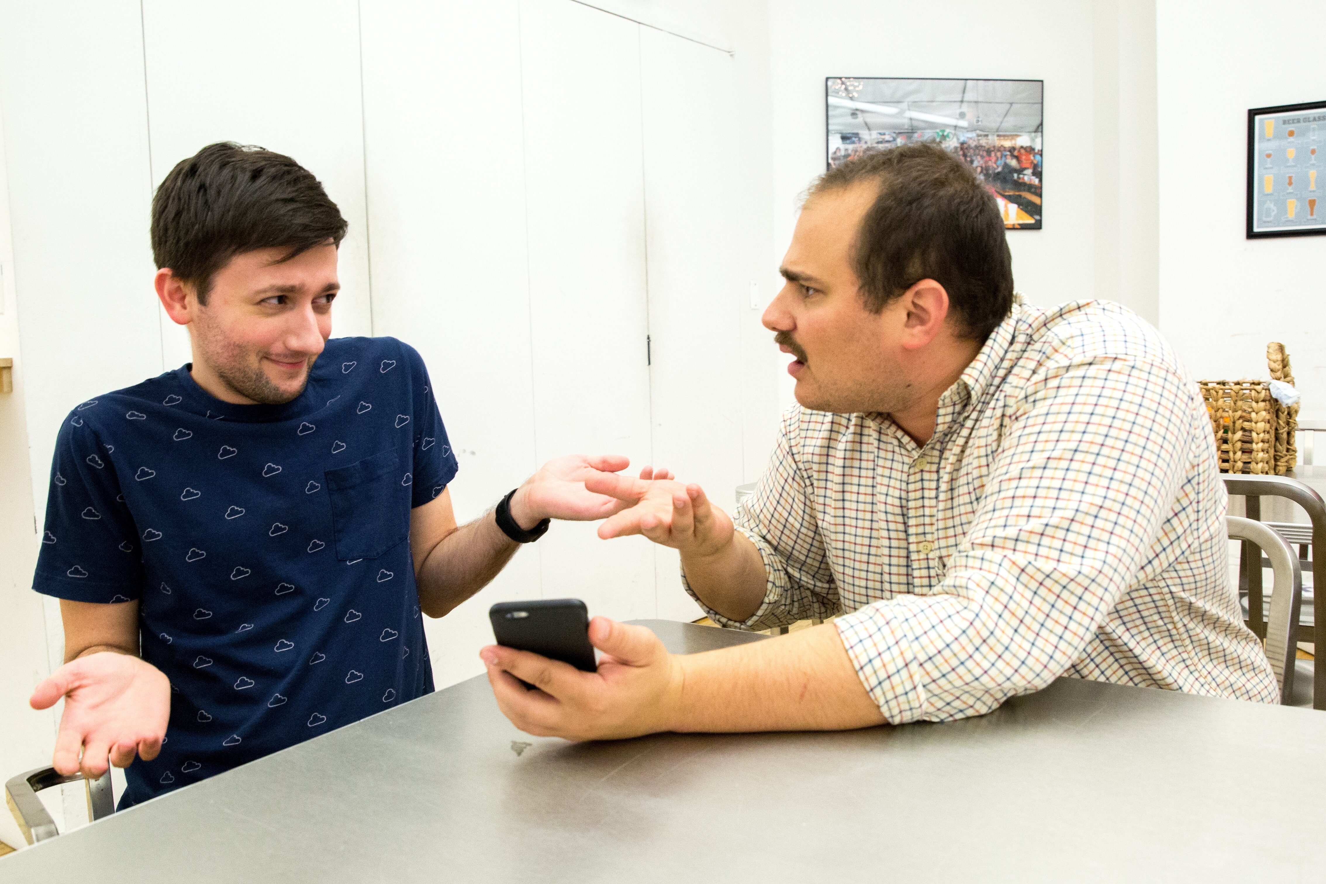 man with iphone scolding other man