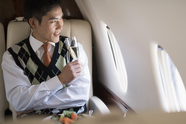 well-dress business man first class airplane