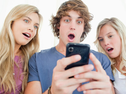 group of young people looking at phone