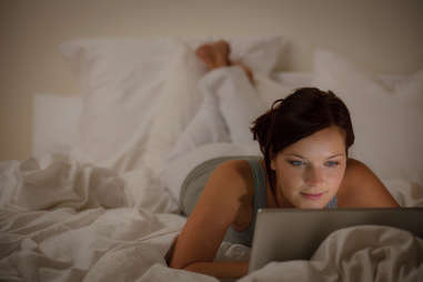 woman on laptop in bed