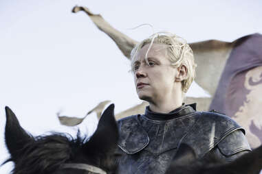 Gwendolyn Christie as Brienne of Tarth in front of Lannister banners