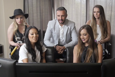 Porn stars in a room watching TV monitor