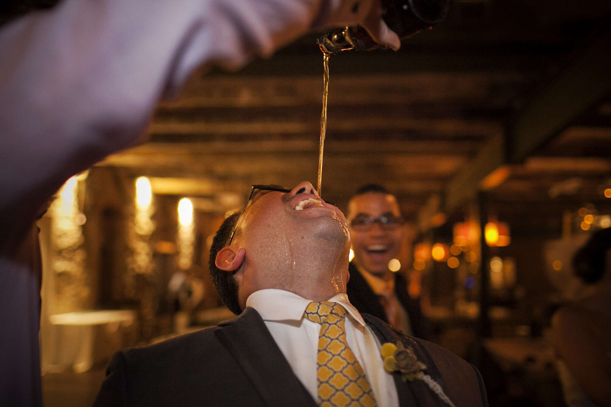 Groomsman drinks at a wedding 