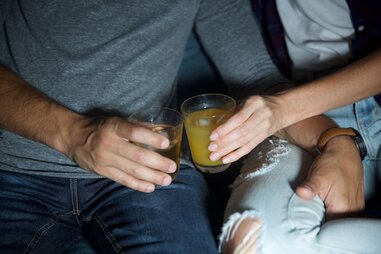 Couple sitting on couch with drinks