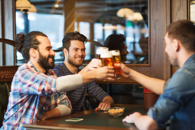 happy friends at a bar drinking beer