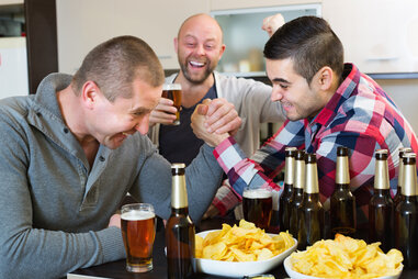 friends drinking and arm wrestling