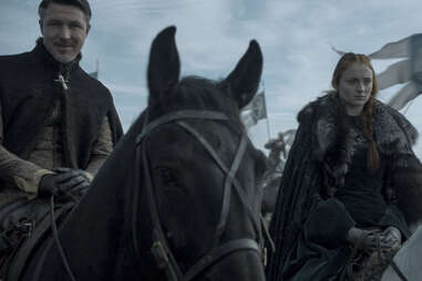 Aidan Gillen as Lord Petyr Baelish, Littlefinger, and Sophie Turner as Sansa Stark, in front of Arryn banners