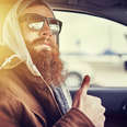 hipster man in car giving thumbs up