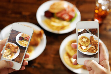Food bloggers taking a picture of food with smartphones
