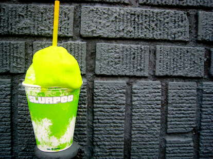 A Slurpee lover displays her free drink outside a 7-Eleven store