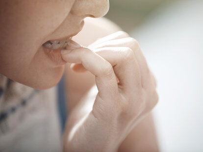 woman biting nails close up