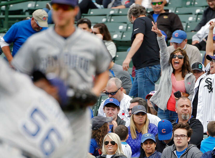 Cubs fan behind one-liner shirts