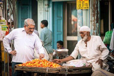 Man buying tomatoes in Indian marketplace
