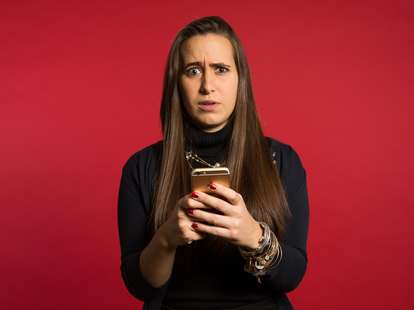 Woman looking anxious looking at iPhone