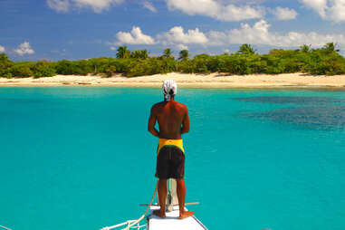 man alone on boat looking at island
