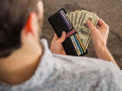 man pulling cash out of his wallet