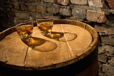 Glasses of whiskey on a barrel
