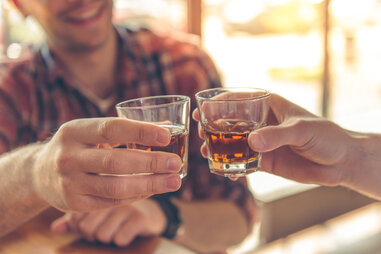 two whiskey glasses cheersing
