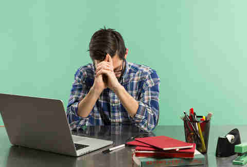 man bored at his office work desk