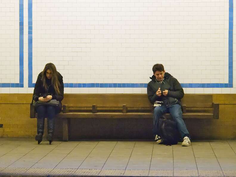 two people using cell phones at subway station