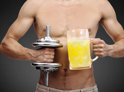 guy holding beer and dumbbell