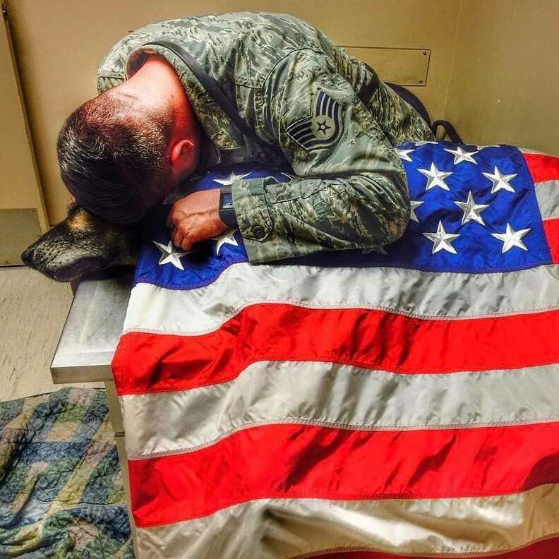 Solider Kyle Smith crying over the body of his beloved dog, Bodza, who once worked as a bomb detector for the U.S.air force