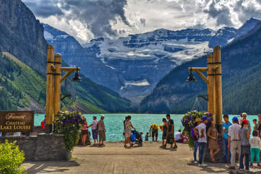 people gathered near lake louise surrounded by mountains