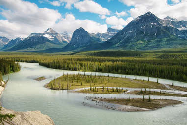 a river running past enormous mountains
