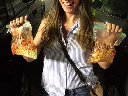 woman carrying bags of spaghetti