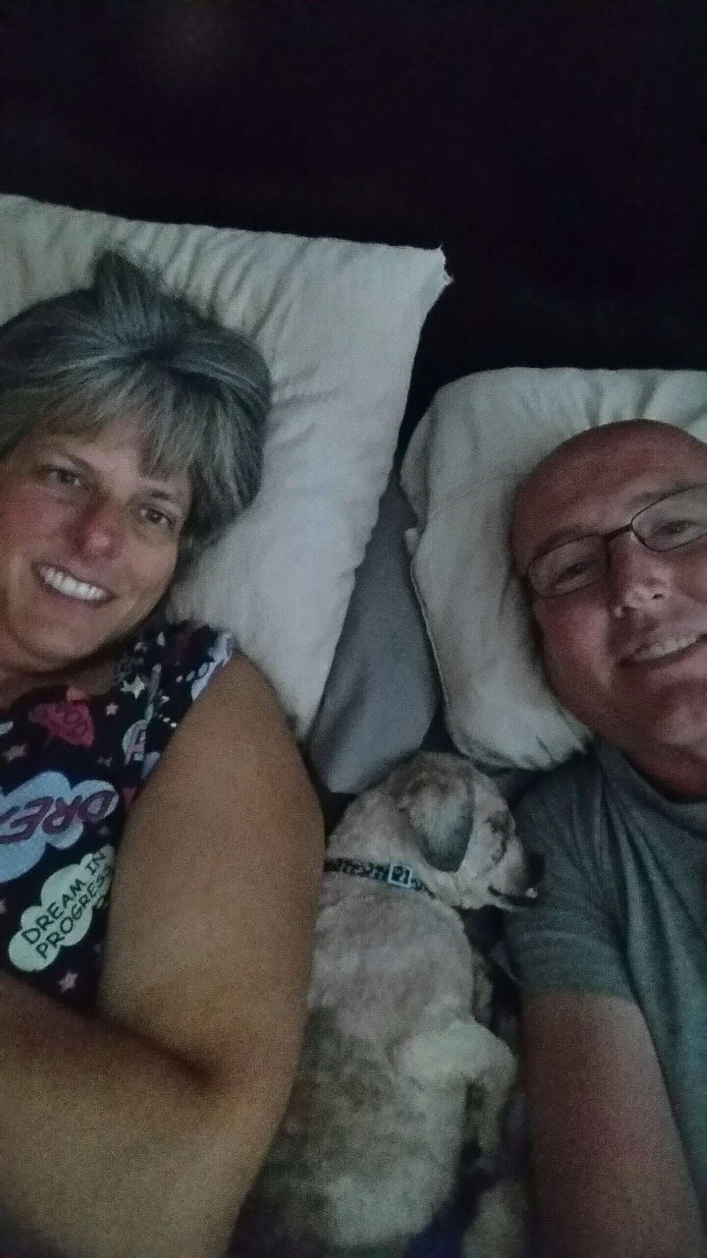 Rescue dog in bed with man and woman