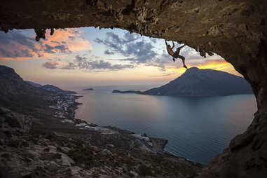man scaling a cliff in kalymnos, greece
