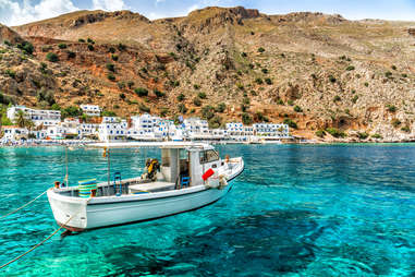 boat floating atop transparent waters of crete
