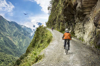 two people biking along a steep mountain road in Bolivia