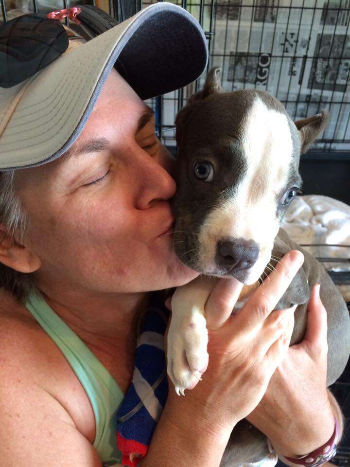 Woman kissing sick puppy