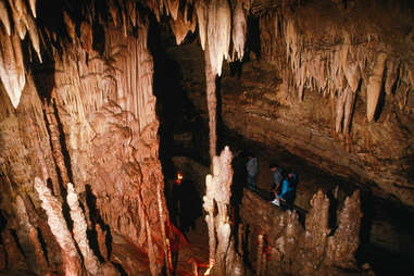 people walking through a dark cave 
