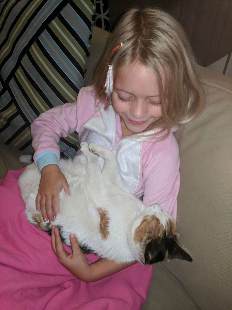 Little girl cuddling cat