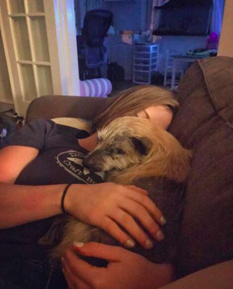 Woman snuggling with rescue dog on couch