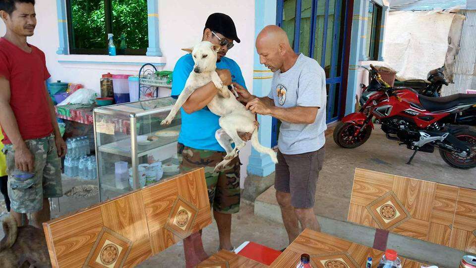 Man holding dog rescued from dog meat restaurant