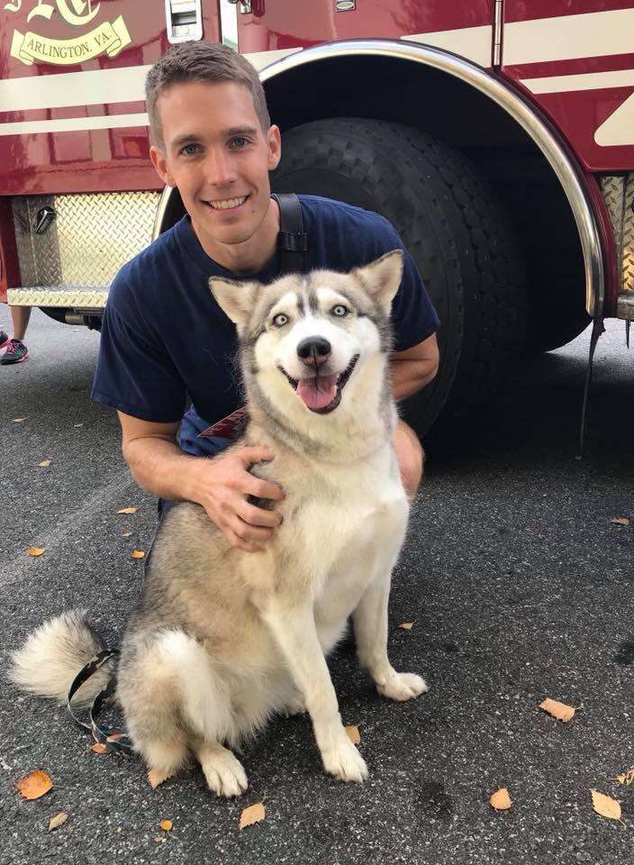 Firefighter posing with shelter dog