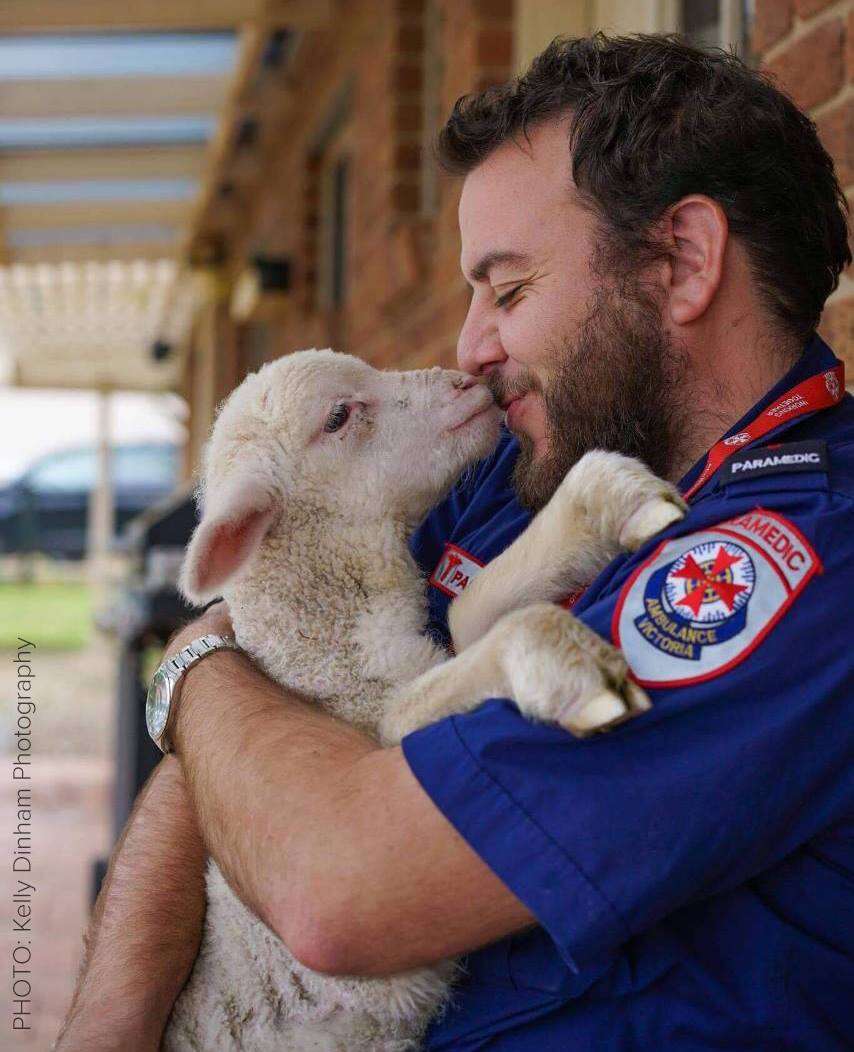 Man holding rescue lamb in his arms