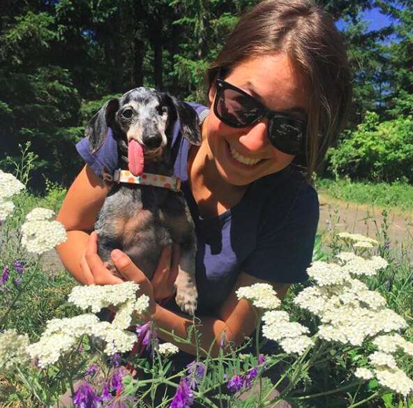 Woman holding senior dog with tongue flopping out