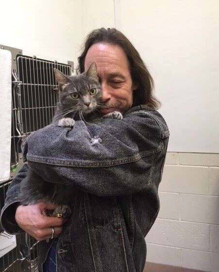 Man hugging his cat at the humane society