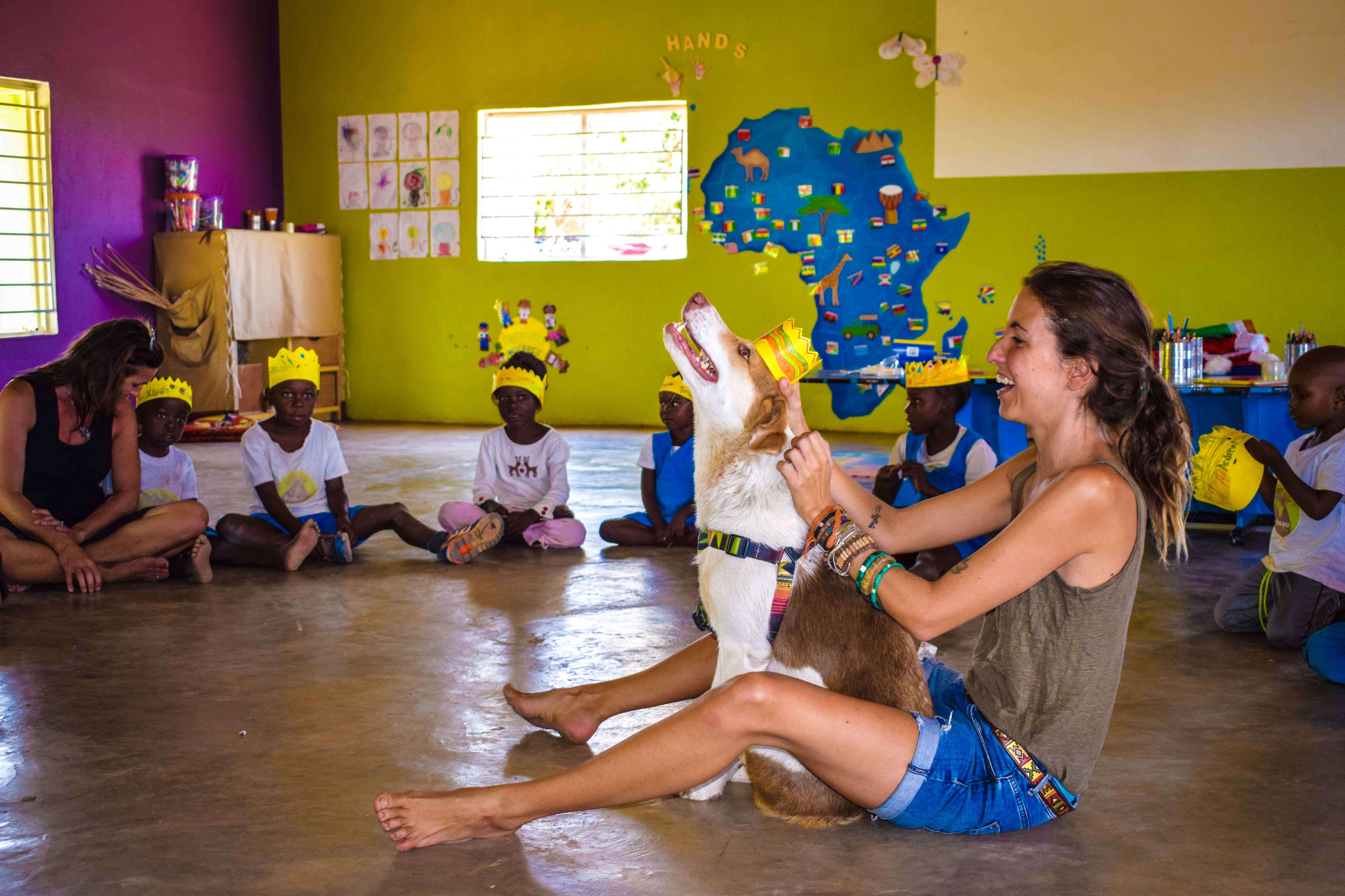 Woman and dog with school children in classroom