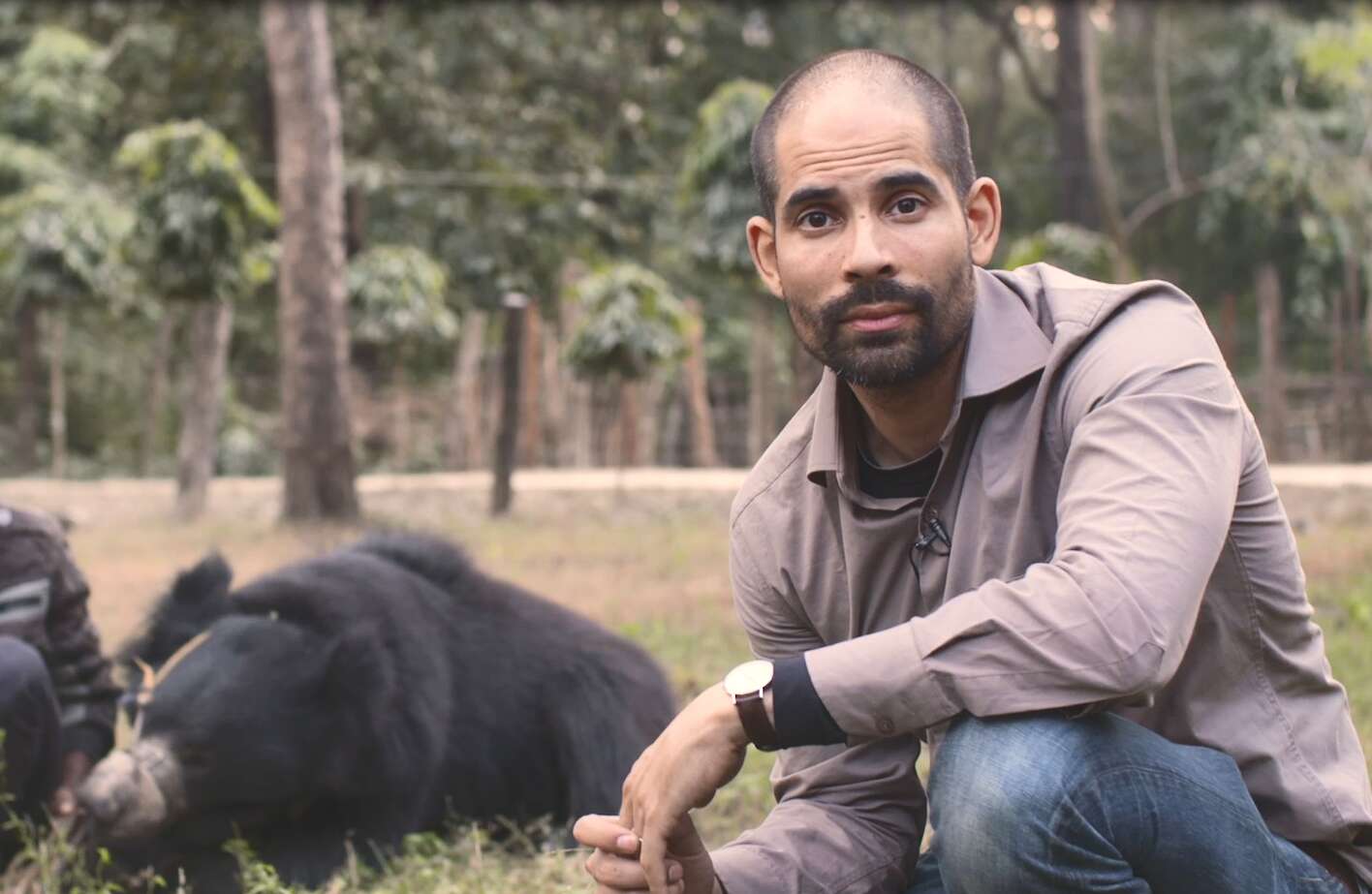 Man posing with bear at forest reserve